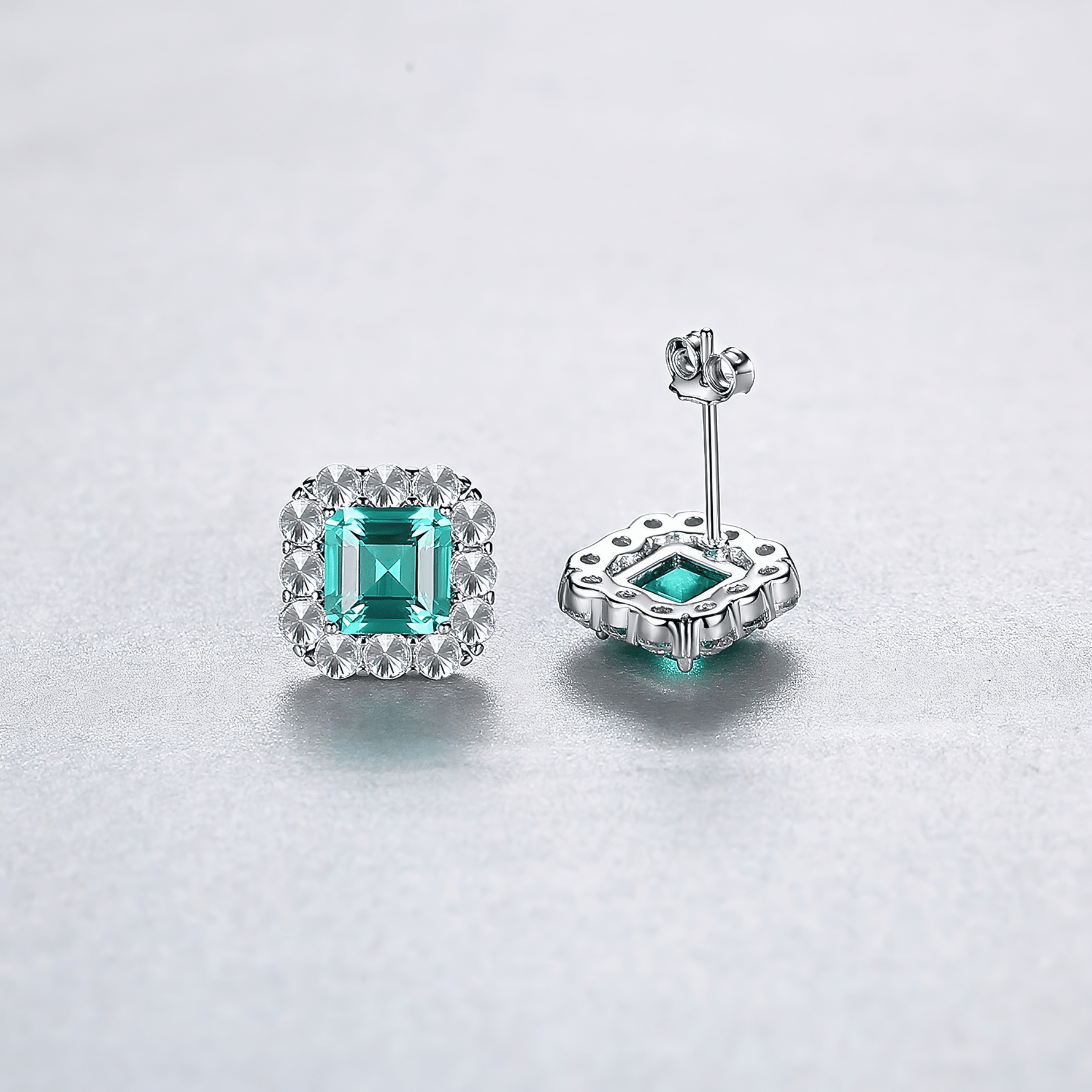 Elegant Emerald - Cut Aqua Blue CZ Halo Stud Earrings in Sterling Silver - NAFALUXE