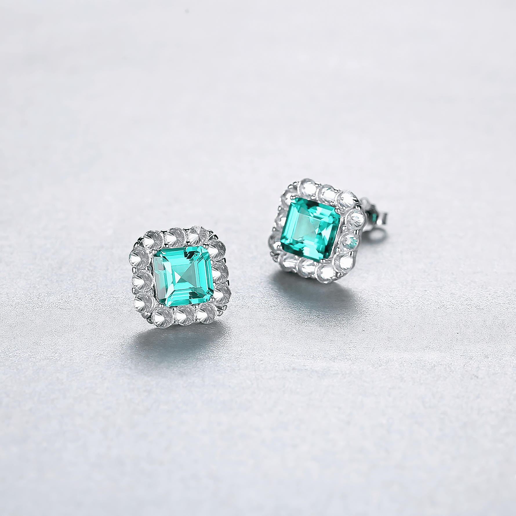 Elegant Emerald - Cut Aqua Blue CZ Halo Stud Earrings in Sterling Silver - NAFALUXE