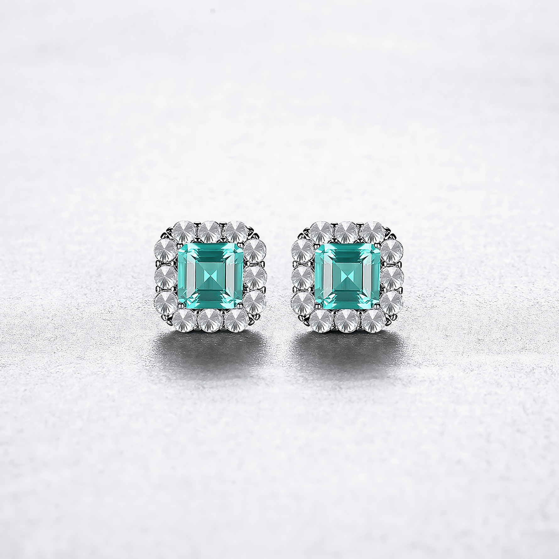 Elegant Emerald - Cut Aqua Blue CZ Halo Stud Earrings in Sterling Silver - NAFALUXE