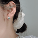 Orecchini a bottone con pietra "occhio di gatto" verde e castone a corona in zirconi, in argento sterling - NAFALUXE